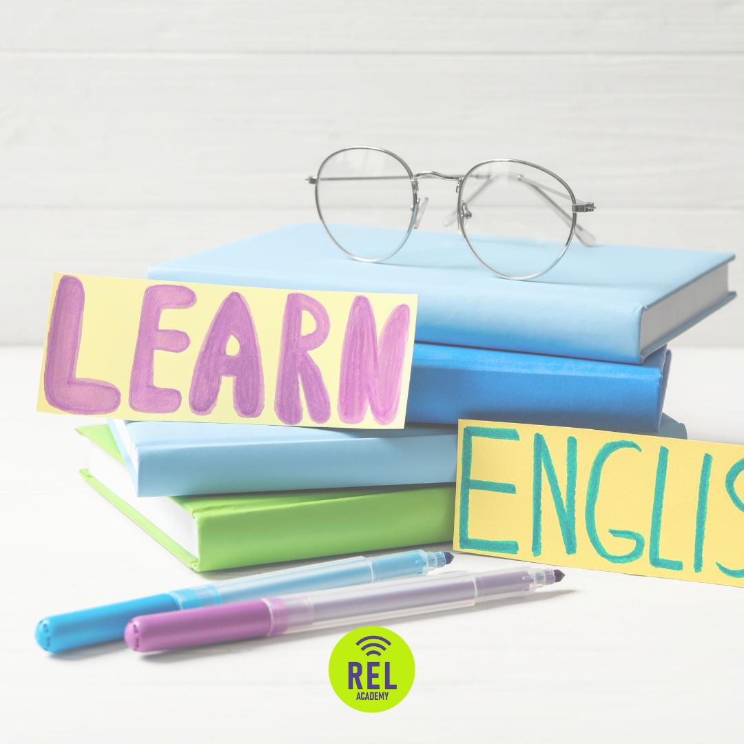Üst üste kitaplar, gözlük ve “Learn English” yazılı renkli kartlar