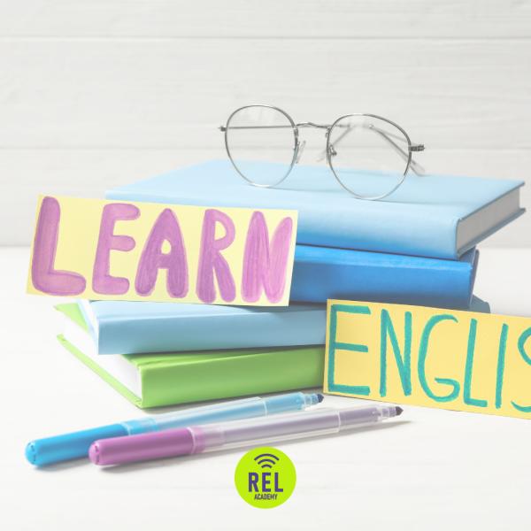 Üst üste kitaplar, gözlük ve “Learn English” yazılı renkli kartlar